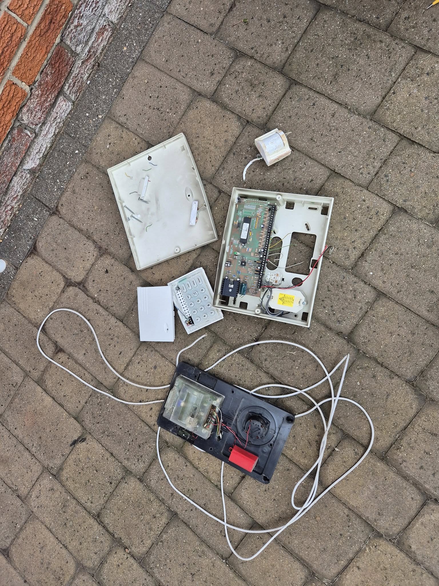 An old alarm panel, keypad and siren, removed and dismantled